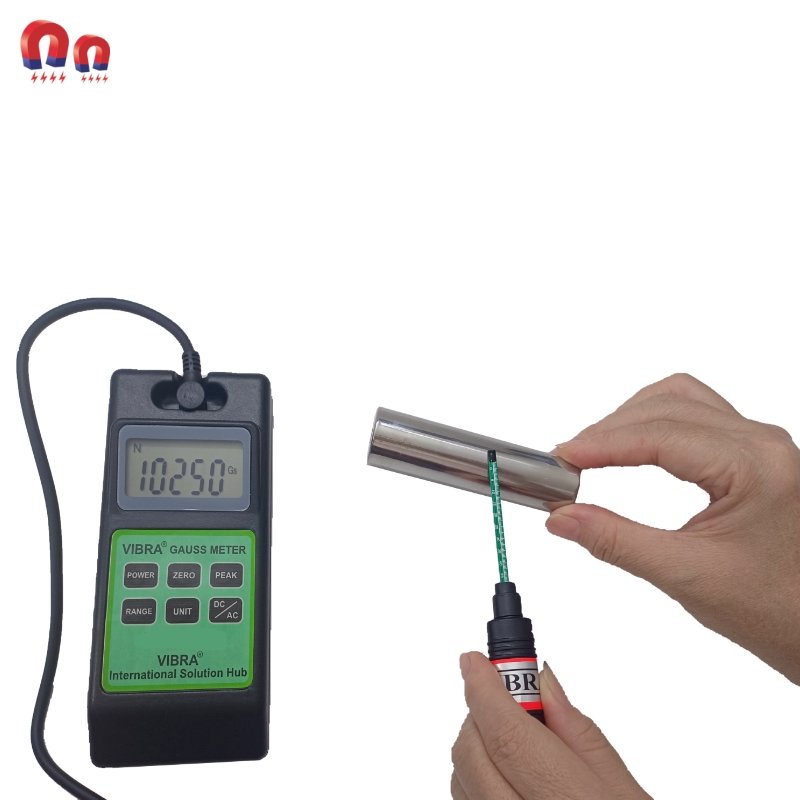 A person uses a meter to measure a metal cylinder, applying liquid to the surface